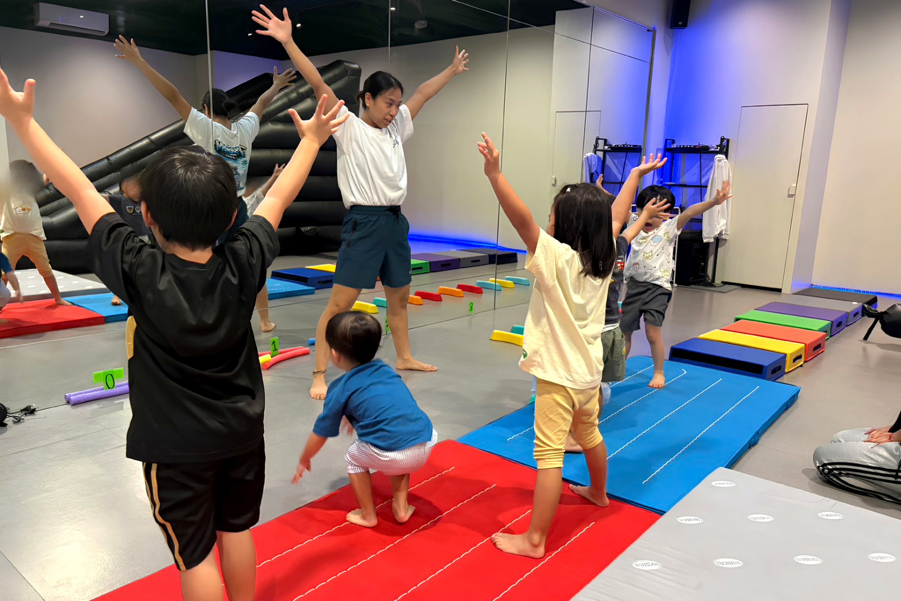 Children and a teacher warming up in a gymnastics class at LIV Dance Academy